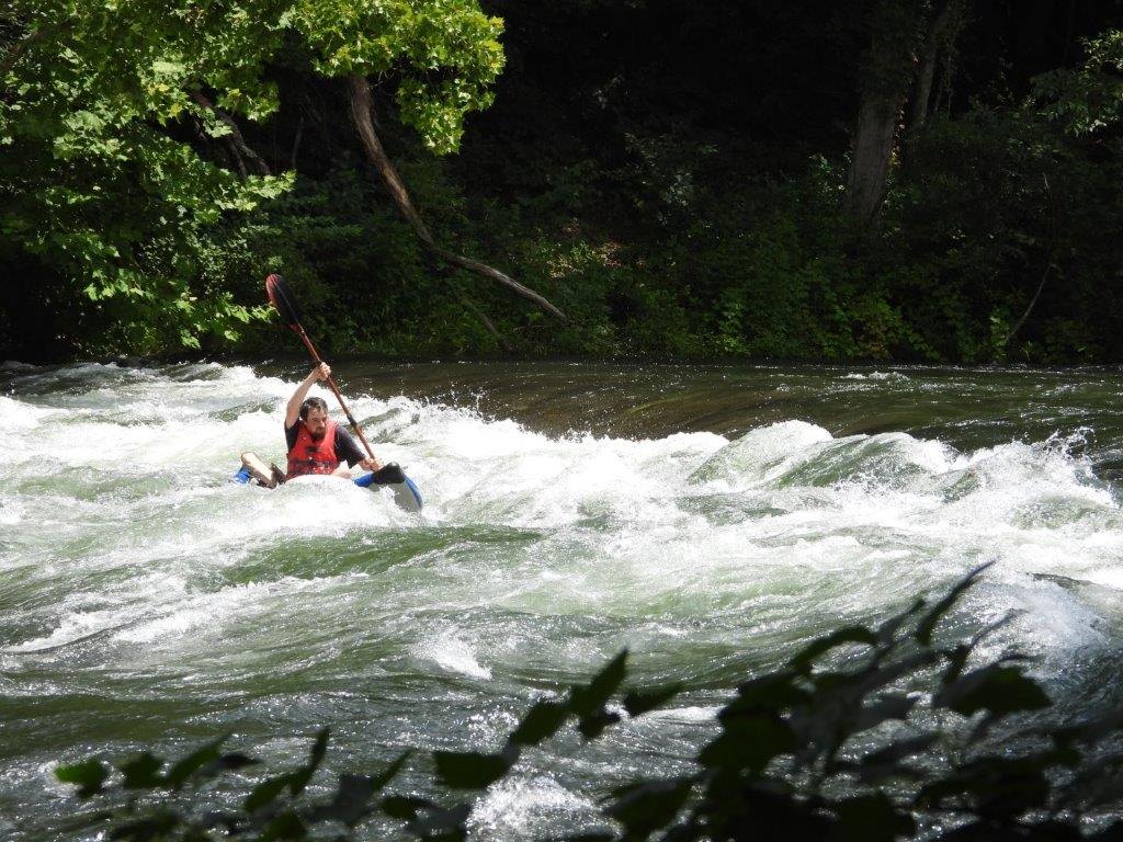 Kayaker paddling through whitewater